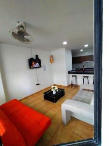 a mirror reflecting a living room with a couch and a kitchen at Apartamento Rodadero Santorini in Santa Marta