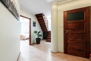 a hallway with a wooden door and a staircase at Panorama Apartment - Happy Hours in Sopot