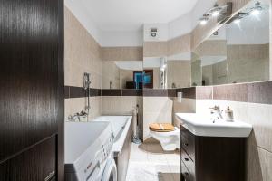 a bathroom with a sink and a toilet and a tub at Panorama Apartment - Happy Hours in Sopot