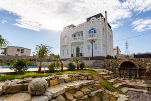 een groot wit gebouw met een stenen muur voor de deur bij Shindisi Residence Boutique Villa in Tbilisi City