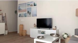 una sala de estar con TV en un armario blanco en Apartamento equipado playa Valencia OnesDeMar, en Valencia