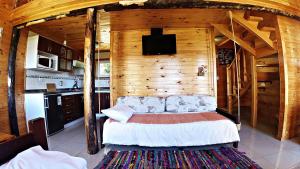 a bedroom with a bed in a wooden cabin at Cabañas Sol de Aucar in Quemchi