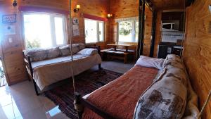 a room with a bed and a couch in a cabin at Cabañas Sol de Aucar in Quemchi
