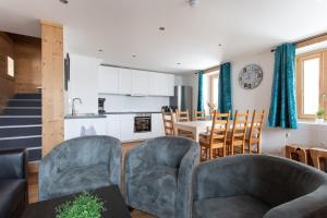 a living room with two chairs and a kitchen at Chalet les Vieux Murs in L'Alpe-d'Huez