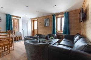 a living room with a couch and chairs and a table at Chalet les Vieux Murs in L'Alpe-d'Huez