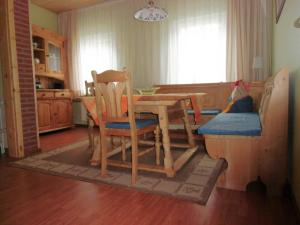 une cuisine avec une table et des chaises en bois ainsi qu'une salle à manger dans l'établissement Ferienhaus Matti, à Kamschlacken