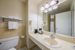 La salle de bains est pourvue d'un lavabo, d'un miroir et de toilettes. dans l'établissement Americas Best Value Inn Brenham, à Brenham