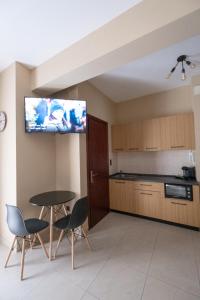 eine Küche mit einem Tisch und Stühlen sowie einen TV an der Wand in der Unterkunft Studio Dieci in Drama