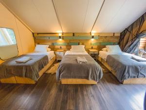 2 camas en una habitación con suelo de madera en Matapiojo Lodge, en Futaleufú