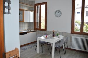 uma cozinha com uma mesa com cadeiras e um relógio na parede em Noemi Venice Home em Marghera