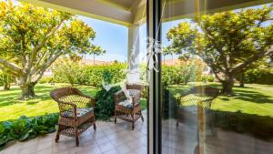 a patio with wicker chairs and a view of a yard at Chalé Davim com piscina -Tranquilidade e conforto in Louriçal