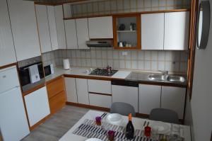 a kitchen with white cabinets and a table with chairs at Noemi Venice Home in Marghera