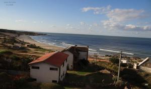 uma casa numa colina ao lado de uma praia em La Posada em Punta Del Diablo