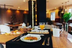 a table with a plate of food and a glass of orange juice at LOTE20 Hotel Boutique in Bento Gonçalves