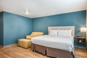 une chambre avec un grand lit et une chaise dans l'établissement WoodSpring Suites Bakersfield East, à Bakersfield 12 autres photos