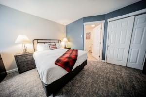 1 dormitorio con 1 cama con manta a cuadros en Grand Lake Lodge en Grand Lake