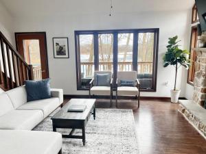 a living room with a couch and a table at Highland House: Lakefront, Hot Tub, Views, Private in East Stroudsburg