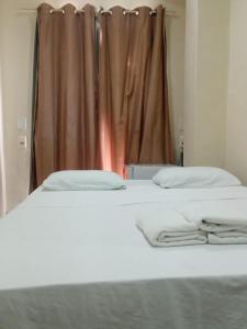 a bedroom with two beds and a curtain at Boulevard Bed & Breakfast in Rio de Janeiro