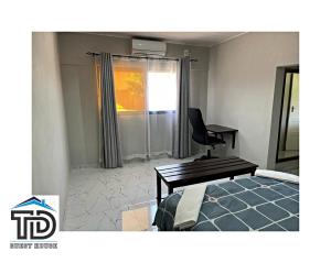 a room with a bed and a desk and a chair at TD Guest House 5 Lite in Chimoio