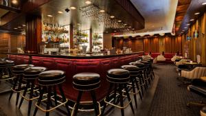 ロサンゼルスにあるThe Adler a Hollywood Hotelの革張りのスツールが備わるバー