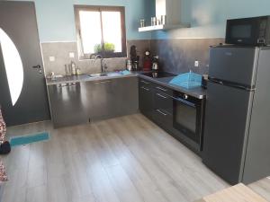 a kitchen with a sink and a refrigerator in it at Le Chalet de l'Authie in Saulchoy