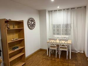 a dining room with a table and a clock on a wall at ARIAN, precioso estudio en Castellón, a un paso de todo! in Castellón de la Plana