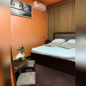 ein Hotelzimmer mit 2 Betten, einem Tisch und einem Stuhl in der Unterkunft HOTEL N1 in Yerevan