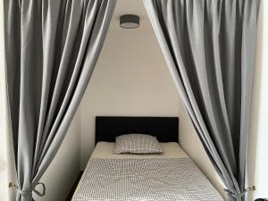 een bed in een kamer met grijze gordijnen bij Ferienwohnung am Hillestausee in Winterberg