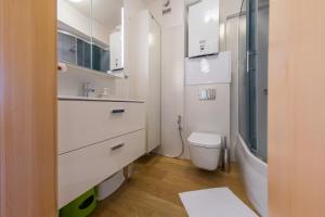 biała łazienka z toaletą i umywalką w obiekcie Komfortowy Apartament w centrum Ustronia w Ustroniu +26 zdjęć