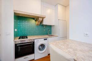 une cuisine avec un lave-linge et un comptoir dans l'établissement 7ti7 Telhal apartment with a lovely Backyard, à Lisbonne