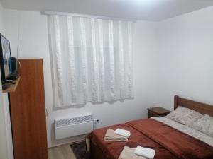 a bedroom with a bed and a window with towels on it at Apartment Sailor in Žabljak