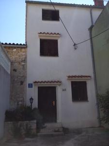 a white building with a door and two windows at Holiday Home Angela in Medulin