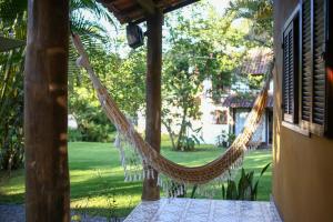 a hammock hanging from a porch with a yard at Casa Park in Paraty