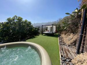 a tub of water in a yard with a garden at Viuter Rural Cave House El Refugio de Miguel in Vega de San Mateo