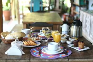 a table with breakfast foods and drinks on it at Casa Park in Paraty