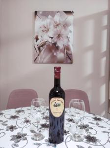a bottle of wine sitting on a table with glasses at Apartman Stanišić Pale in Pale