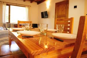 a wooden table with plates and glasses on it at Casa Ñire in El Bolsón +18 photos