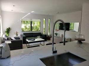 cocina y sala de estar con sofá y lavamanos en Casa Tua in Design District by Midtown, Brickell, Downtown, Airport & 10 min to Miami Beach, en Miami