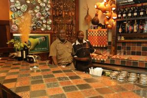 two men standing behind a counter in a bar at Opuwo Country Lodge in Opuwo