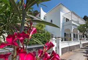 a white house with pink flowers in front of it at Villa Mariuccia Capri in Capri