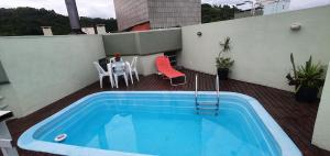 una piscina en un balcón con mesa y sillas en COBERTURA COM PISCINA, en Florianópolis