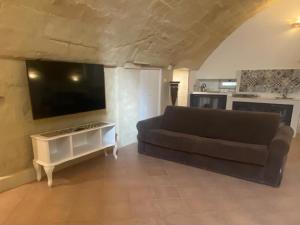 a living room with a couch and a flat screen tv at Le Case Nuove Room in Matera