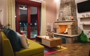 salon z żółtą kanapą i kominkiem w obiekcie Olive Tree Suites w mieście Eleonas