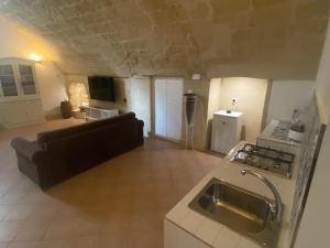 a large living room with a couch and a kitchen at Le Case Nuove Room in Matera