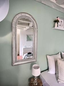 a mirror hanging on a wall next to a bed at La Plume - Hypercentre - Place Plumereau in Tours