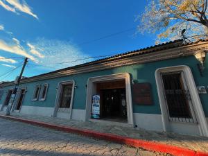 un bâtiment bleu avec une porte ouverte sur une rue dans l'établissement Hotel Mansion Del Valle, à San Cristóbal de Las Casas