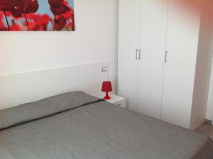 a bedroom with a bed and a red lamp on a night stand at Appartamenti Villa Padania in Malcesine