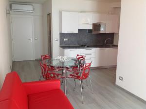 kuchnia i jadalnia ze szklanym stołem i czerwonymi krzesłami w obiekcie Appartamenti Villa Padania w mieście Malcesine +13 zdjęć