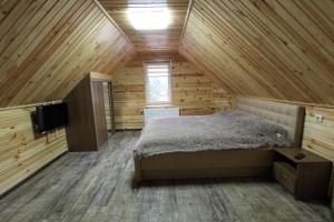 una camera da letto in una cabina di legno con un letto e una TV di Melody Hotel a Bukovel