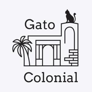 una imagen de un gato en el techo de un edificio y una palmera en Hostel Gato Colonial en Santo Domingo